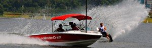 red and white mastercraft boat pulling a skiier