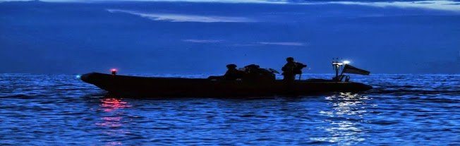 Navy inflatable boat on water at night