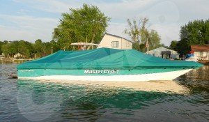 boat covered with a green cover sitting on the water